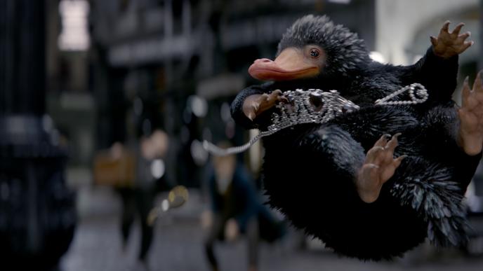A mythical creature that looks like a mix of a hedgehog and a platypus soars through a bustling city square holding diamond jewelry