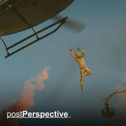 A man jumping from a crane to a helicopter through the air, there is the PostPerspective logo in the bottom left corner.